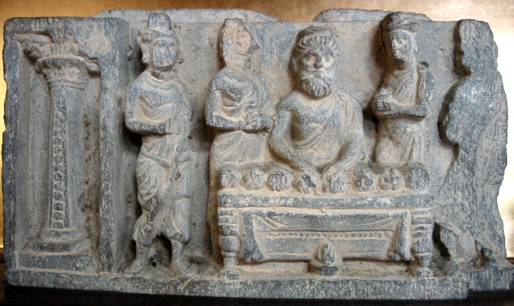 Photo of sculpture of the division of the relics of the Buddha by Drona the Brahmin. Greco-Buddhist art of Gandhara, 2-3rd century CE. Zenyōmitsu-ji, Tokyo.