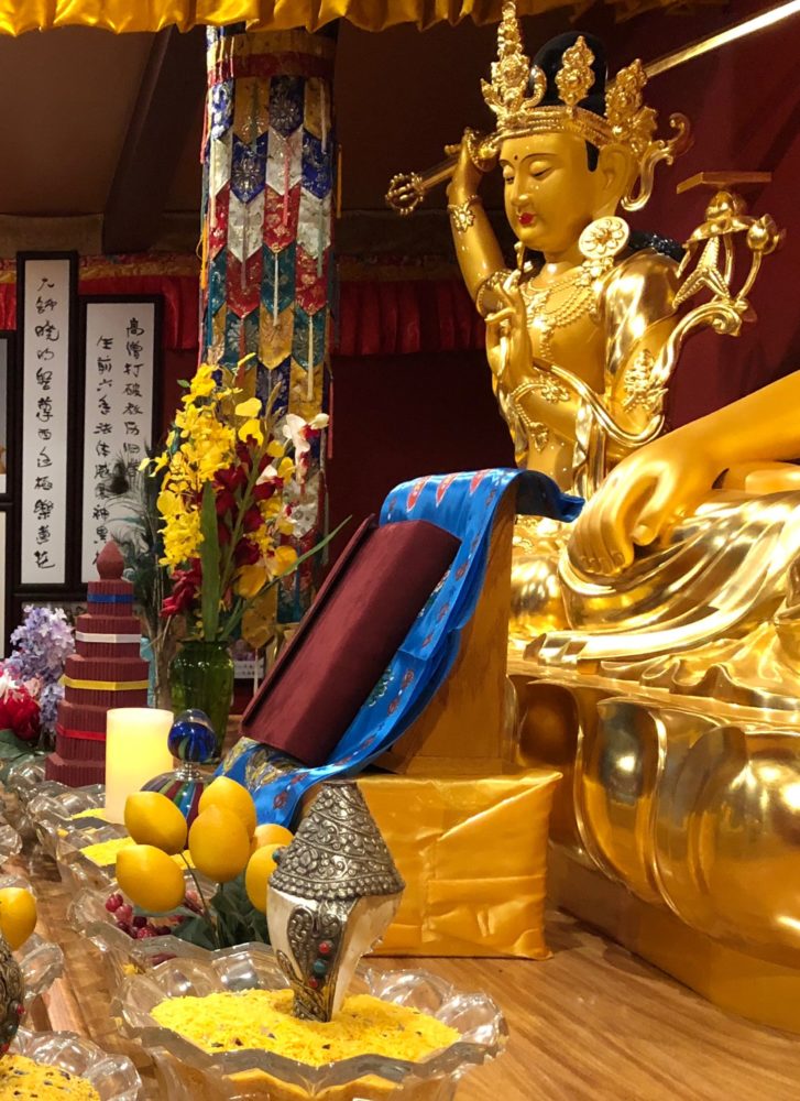 Manjurshri Bodhisattva stands guard over the Chinese edition of 'Expounding the Absolute Truth Through the Heart Sutra' on the altar in the Buddha Hall at the Holy Vajrasana Temple.