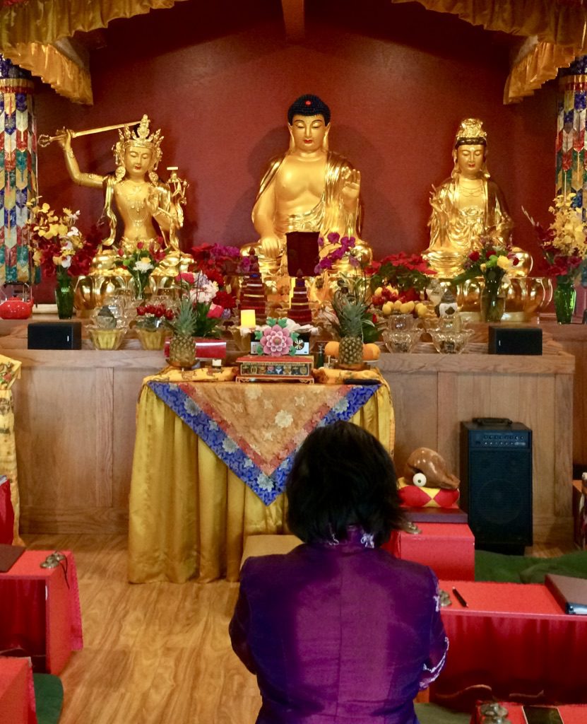 Disciple prostrating to Shakyamuni Buddha and some of the Bodhisattva statues at the Holy Vajrasana Temple.